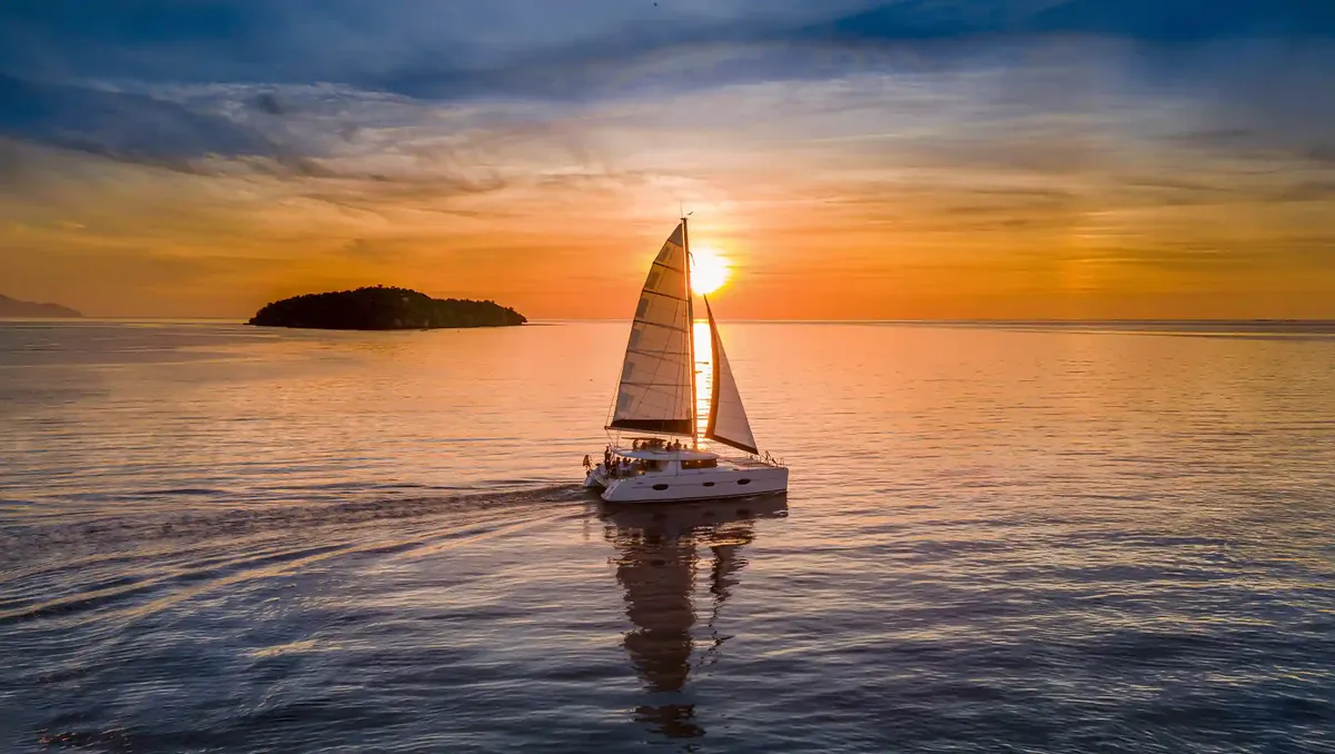 Catamaran under sail at sunset in Indonesian waters